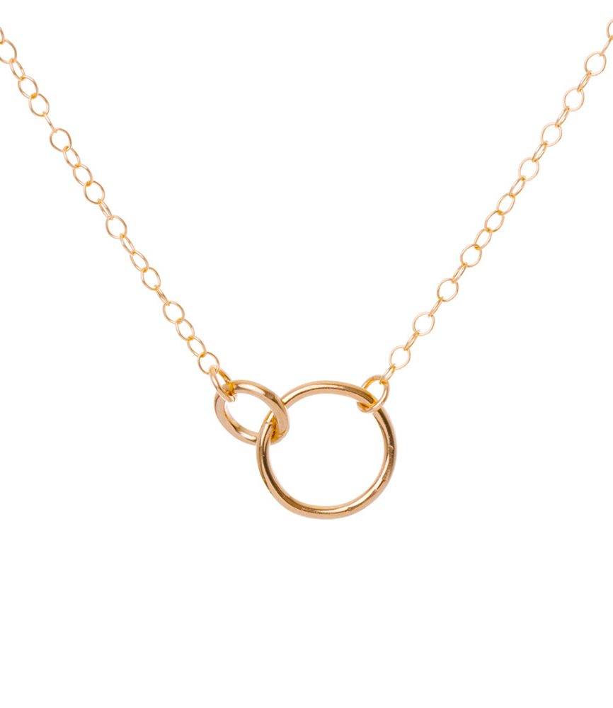 Gold necklace with a circular pendant on a white background